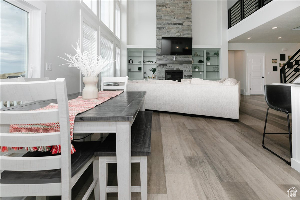 Dining space featuring hardwood / wood-style floors, plenty of natural light, and a towering ceiling