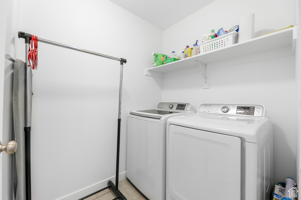 Laundry room with independent washer and dryer and light tile patterned floors