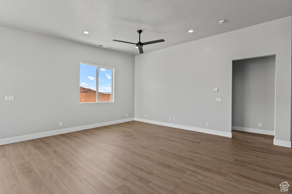 Unfurnished room featuring ceiling fan, visible vents, recessed lighting, wood finished floors, and baseboards