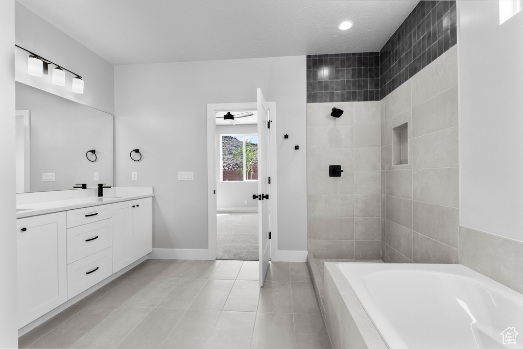 Bathroom featuring a sink, double vanity, tile patterned floors, tiled shower, and a garden tub
