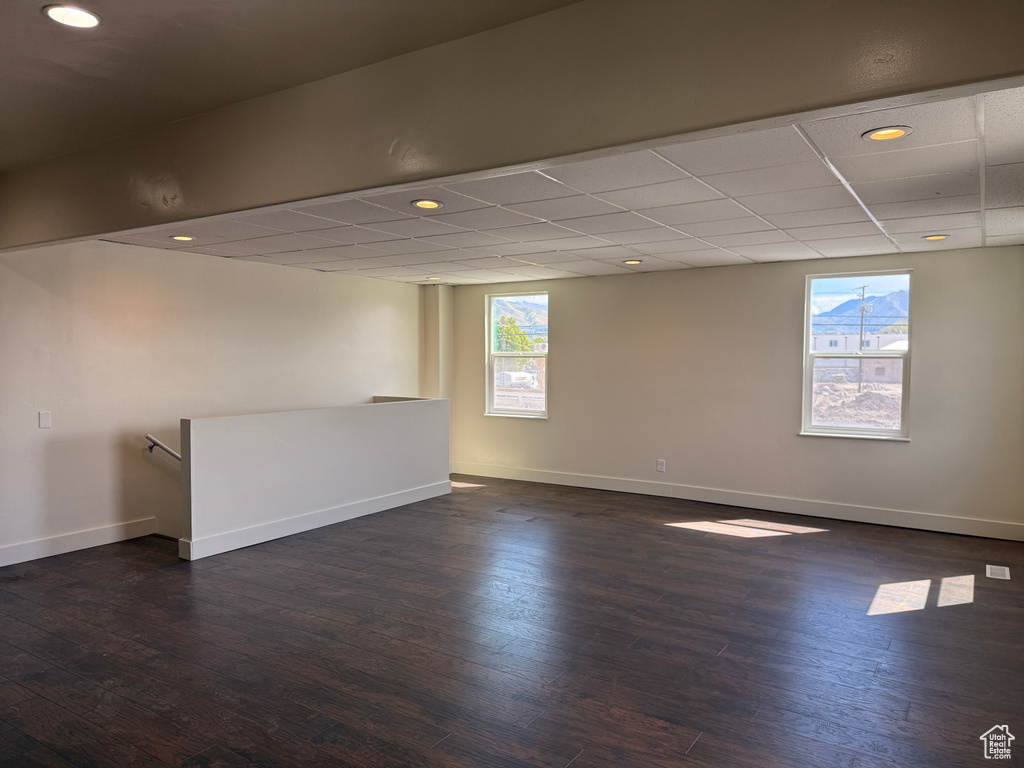 Unfurnished room featuring plenty of natural light, recessed lighting, dark wood-style flooring, and baseboards