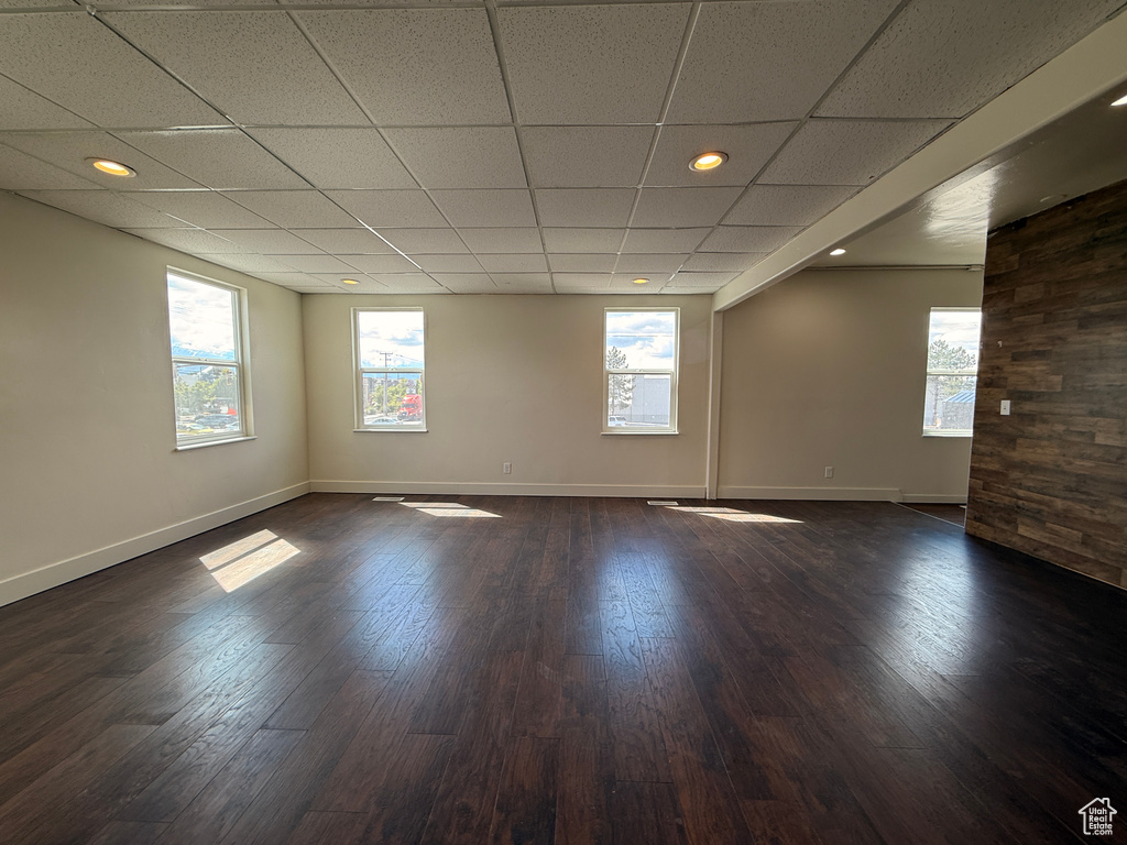 Unfurnished room with baseboards, dark wood finished floors, and a wealth of natural light