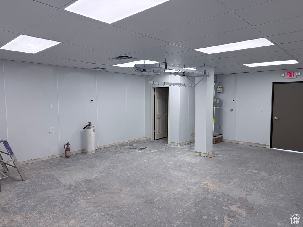 Below grade area with strapped water heater and a drop ceiling
