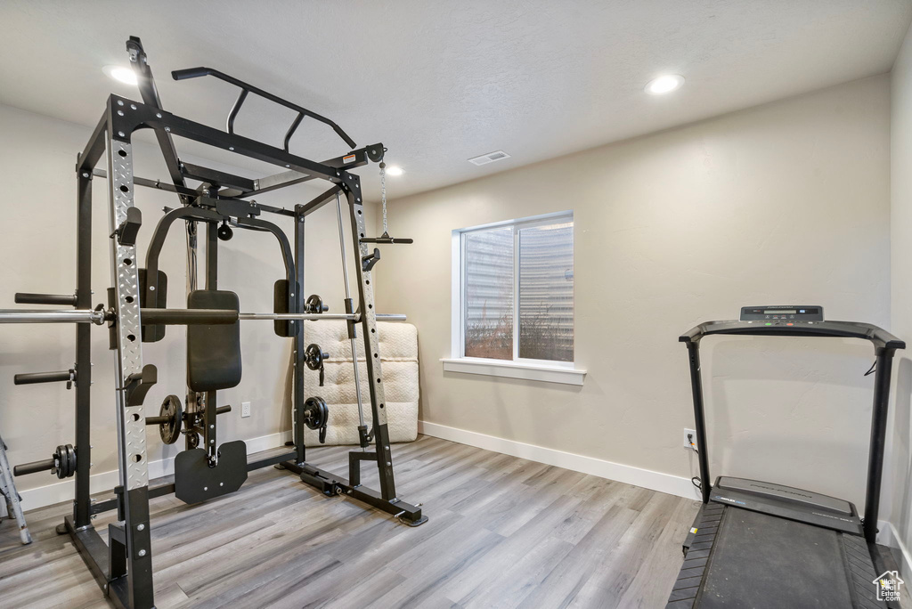 Exercise area with light hardwood / wood-style flooring