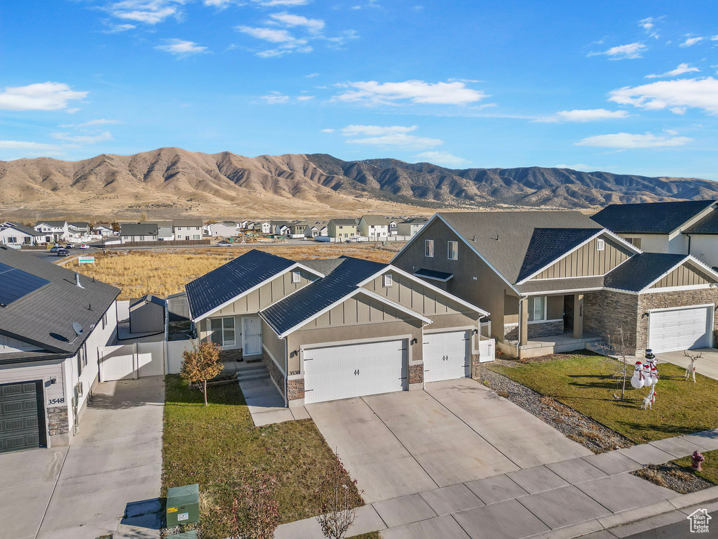 View of front facade with a mountain view, a garage, and a front yard