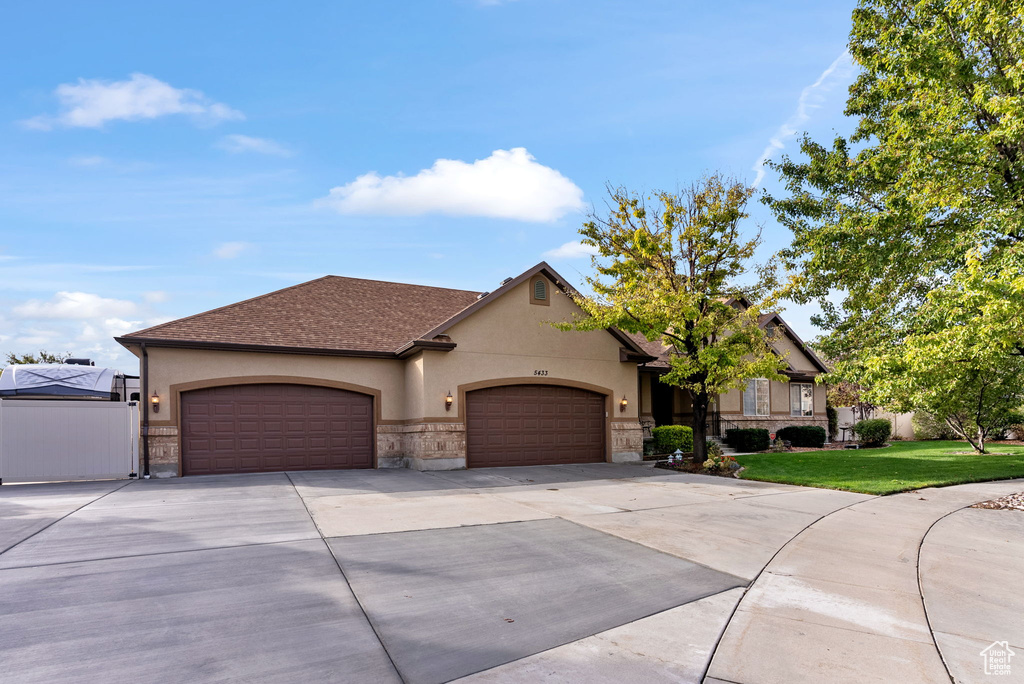 View of front of house with a garage and a front lawn