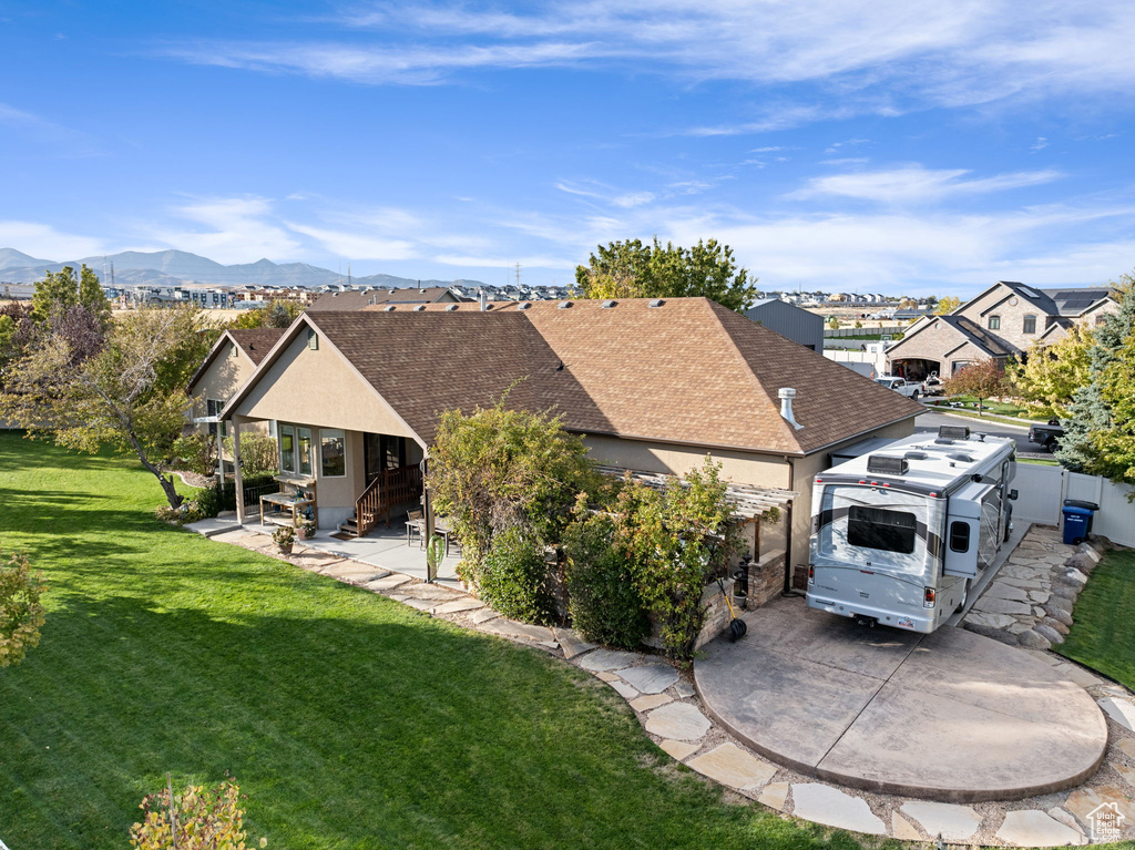 Rear view of property with a mountain view and a yard