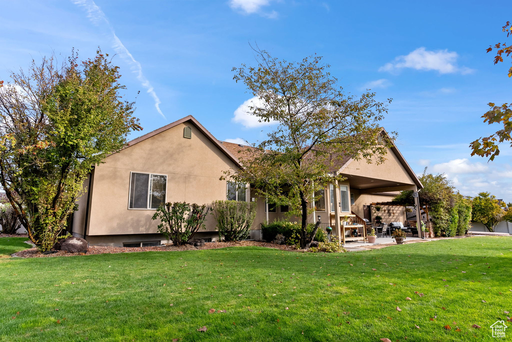 Exterior space with a patio and a lawn