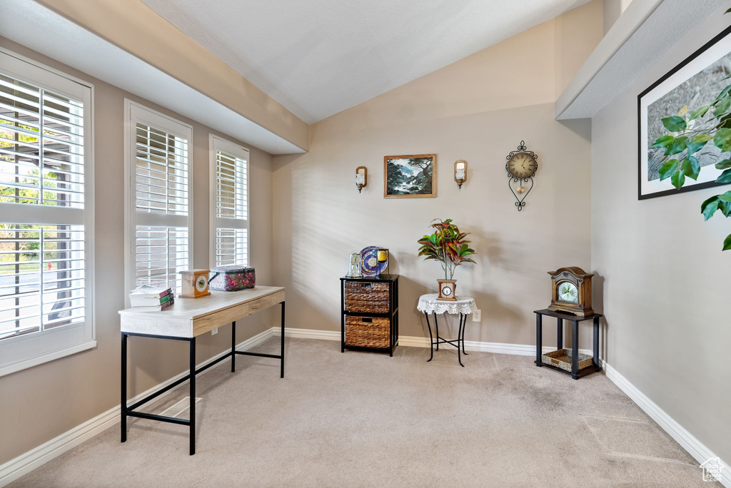 Office featuring light colored carpet, vaulted ceiling, and plenty of natural light