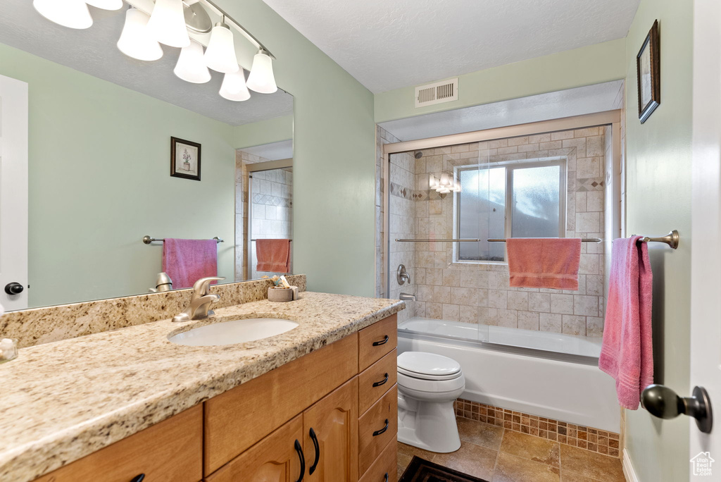 Full bathroom with toilet, combined bath / shower with glass door, a textured ceiling, and vanity