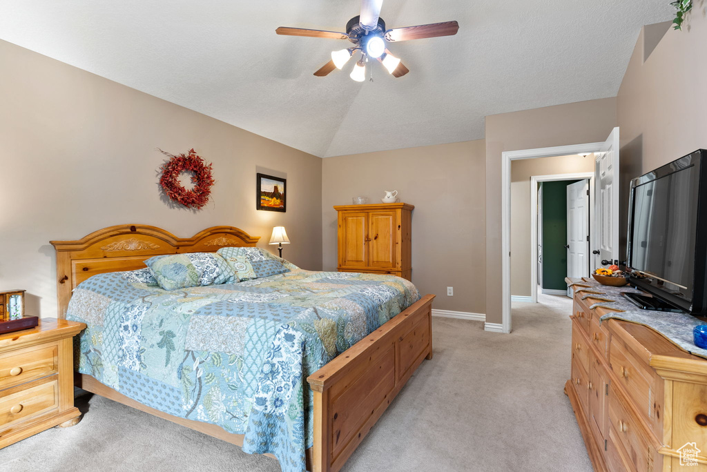 Bedroom with light colored carpet, vaulted ceiling, and ceiling fan