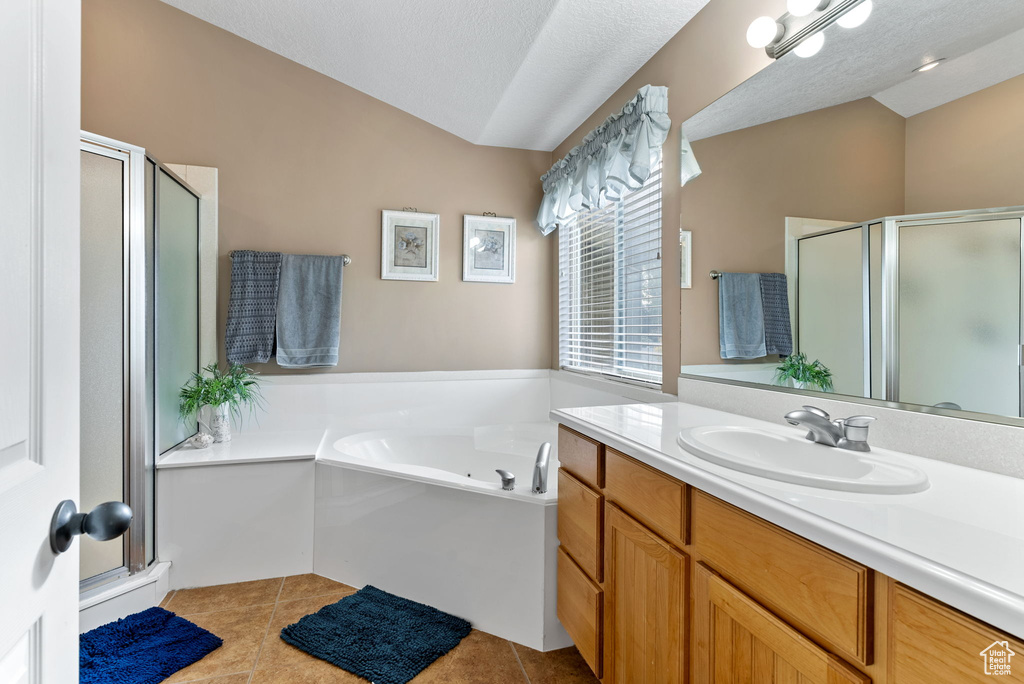 Bathroom featuring a textured ceiling, vanity, tile patterned floors, and independent shower and bath