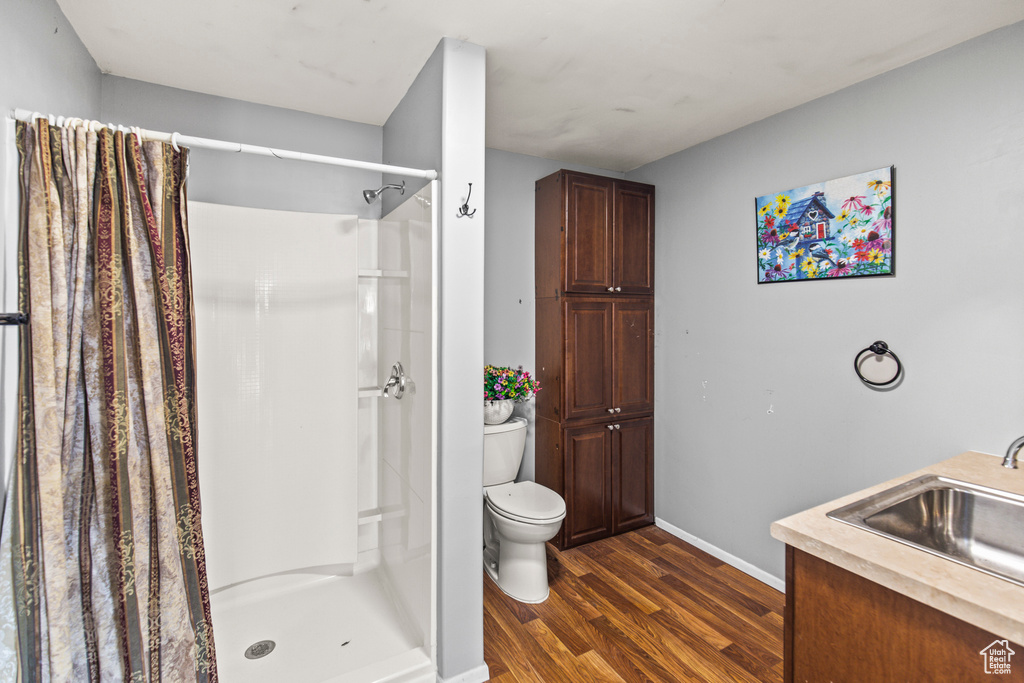 Bathroom with a shower with curtain, toilet, wood-type flooring, and vanity
