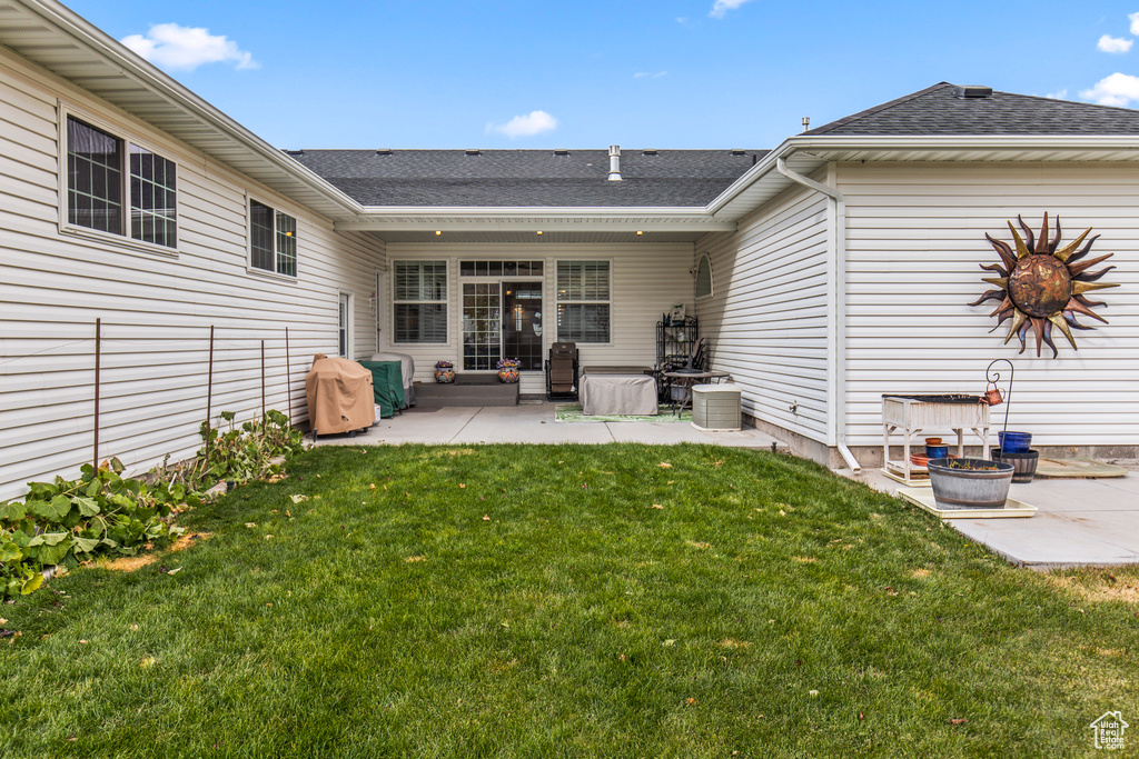 Back of property with a yard and a patio