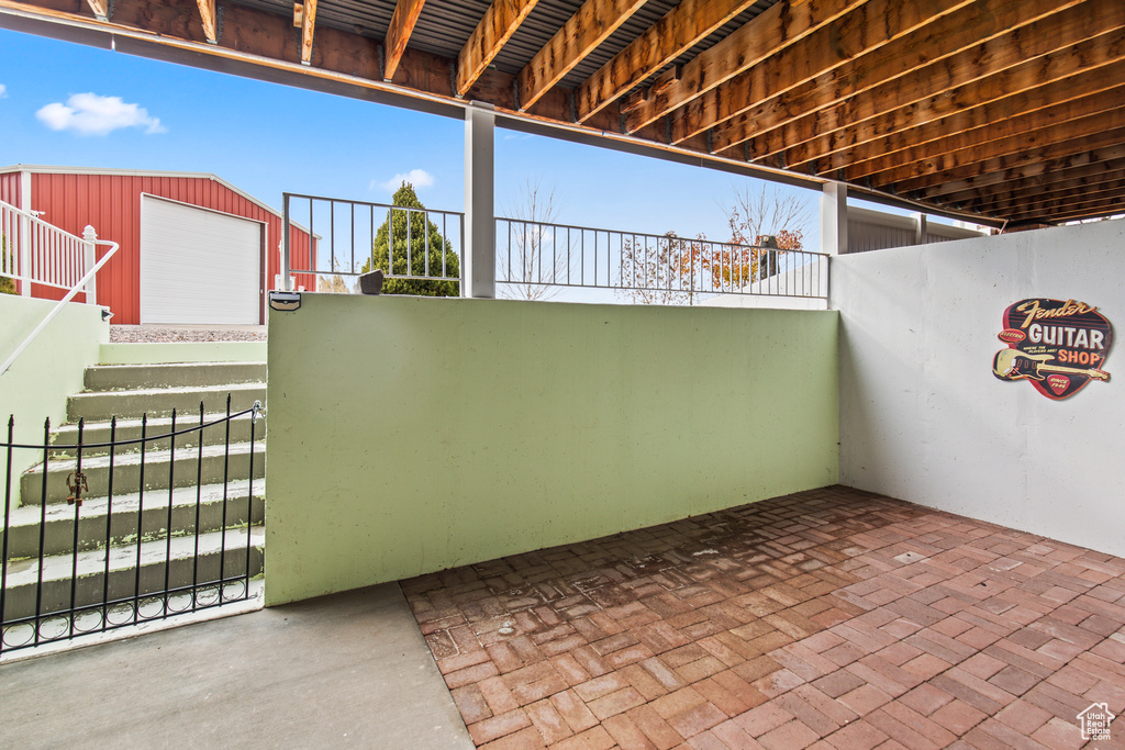 View of patio featuring a garage and an outbuilding
