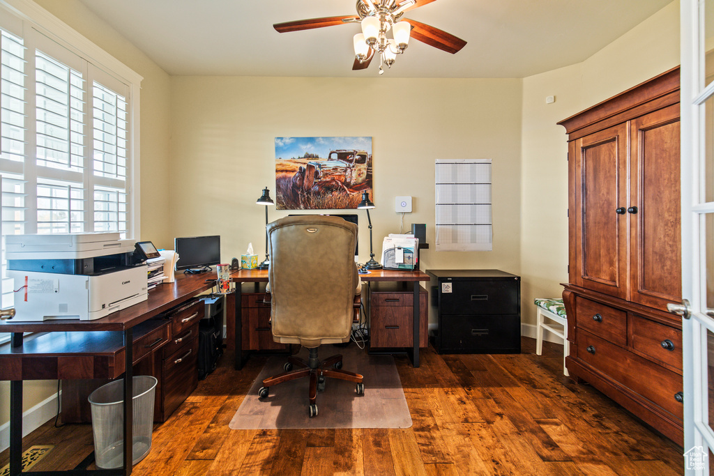 Home office featuring ceiling fan and dark wood-type flooring