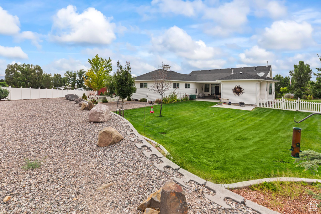 Rear view of house featuring a patio and a fenced backyard
