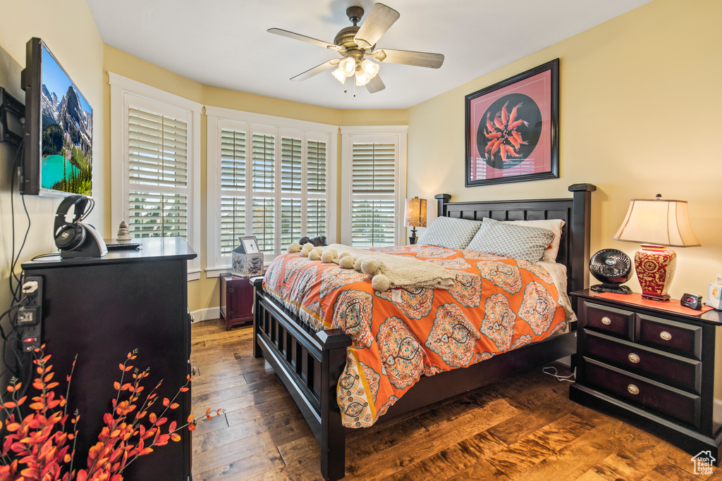 Bedroom featuring ceiling fan, dark hardwood / wood-style flooring, and multiple windows
