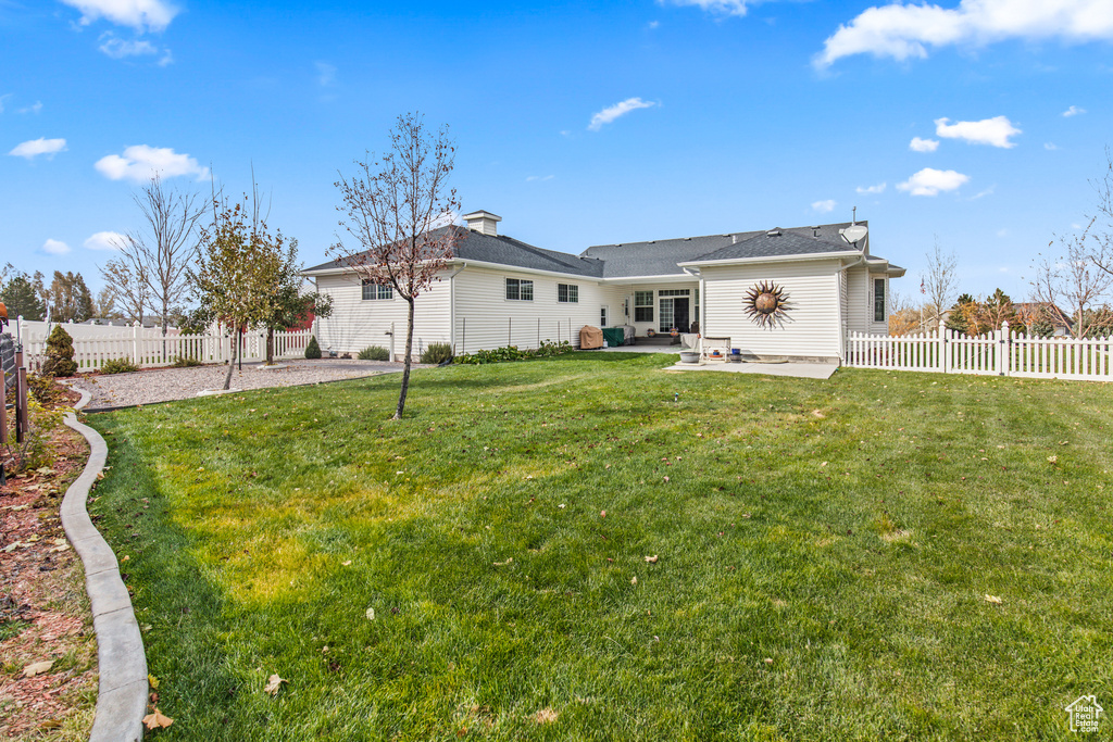 Back of house with a patio area and a yard