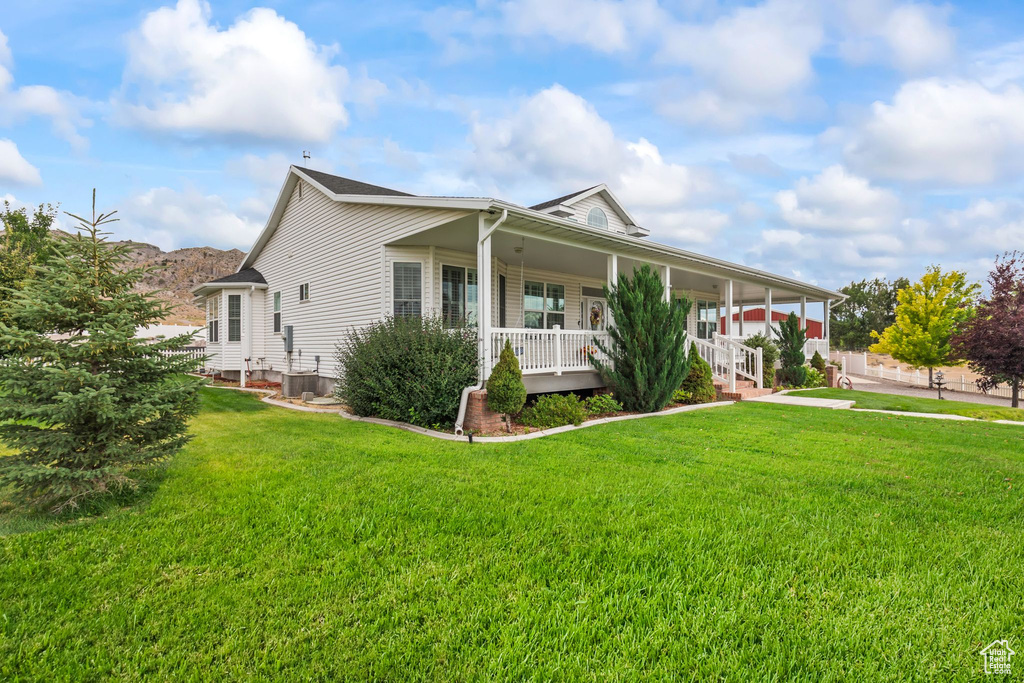 View of front of house with covered porch and a front yard