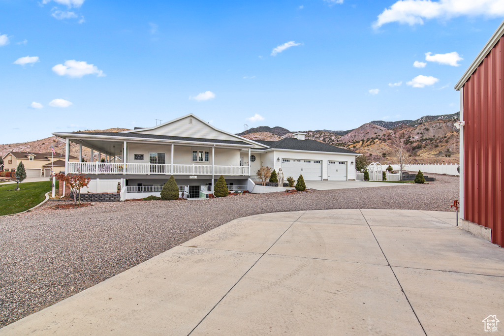 View of front of property featuring a mountain view, a porch, and a garage