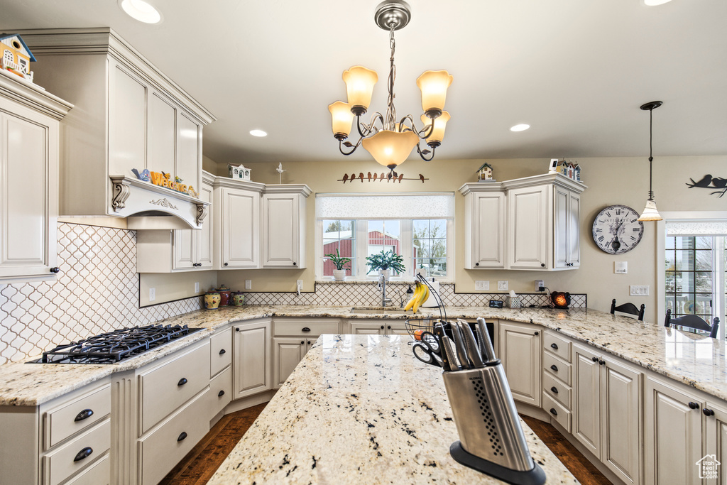 Kitchen with white cabinetry, a wealth of natural light, pendant lighting, and stainless steel gas stovetop
