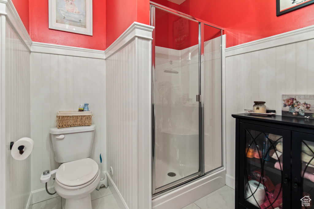 Bathroom with tile patterned floors, toilet, and walk in shower