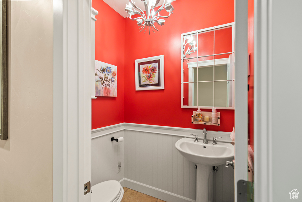 Bathroom featuring a chandelier, tile patterned floors, and toilet