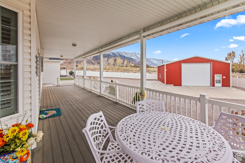 Deck featuring a mountain view, an outdoor structure, and a garage