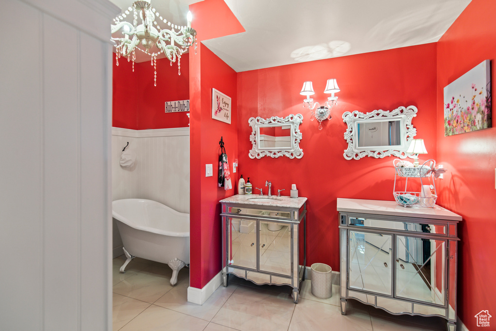 Bathroom featuring tile patterned floors, vanity, a tub, and an inviting chandelier