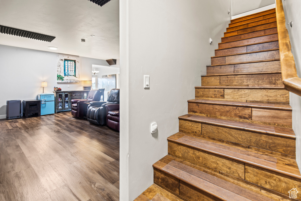 Stairs featuring wood-type flooring and indoor bar