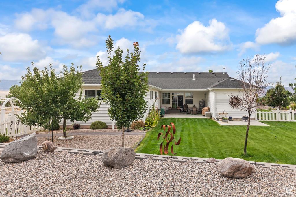 Rear view of house with a patio area and a shingled roof