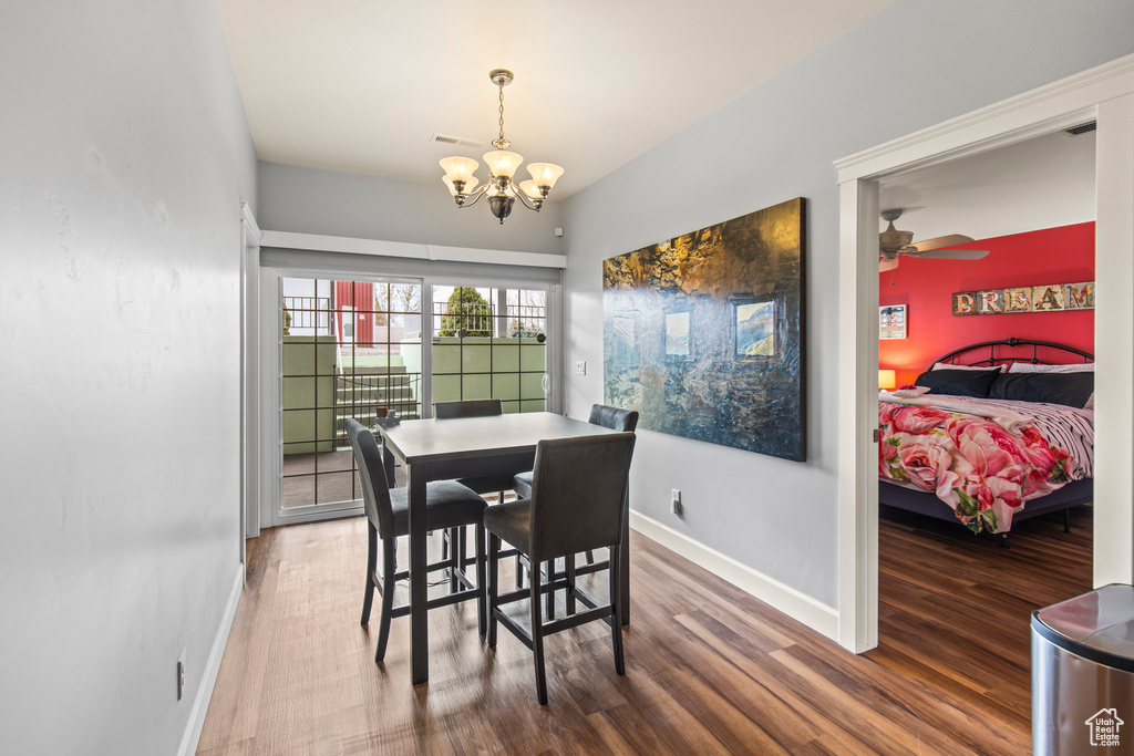 Dining area with hardwood / wood-style floors and ceiling fan with notable chandelier