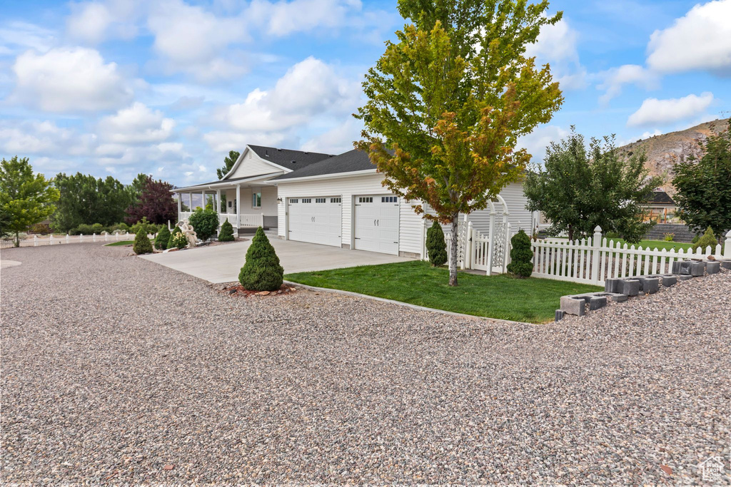 View of front of property with driveway, an attached garage, a porch, and a mountain view