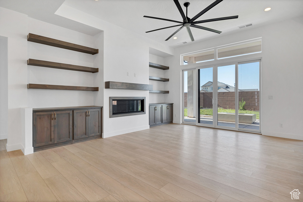 Unfurnished living room with a glass covered fireplace, light wood finished floors, a ceiling fan, and recessed lighting