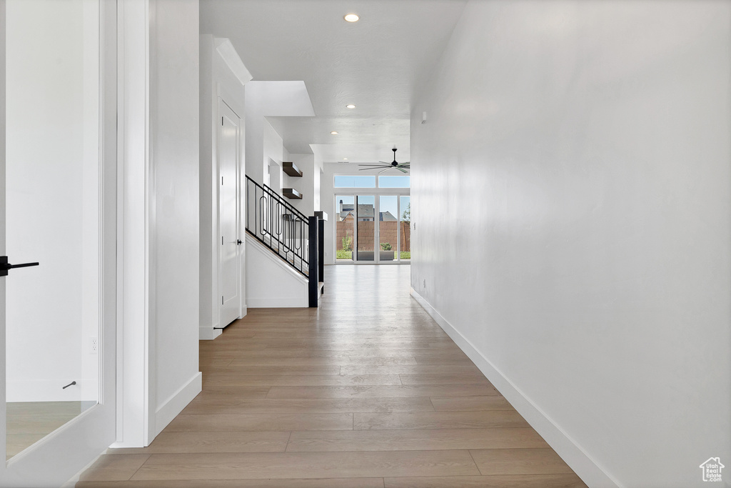 Hall featuring stairs, recessed lighting, and light wood-style floors
