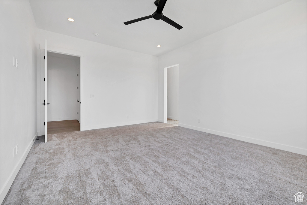 Carpeted empty room featuring a ceiling fan and recessed lighting