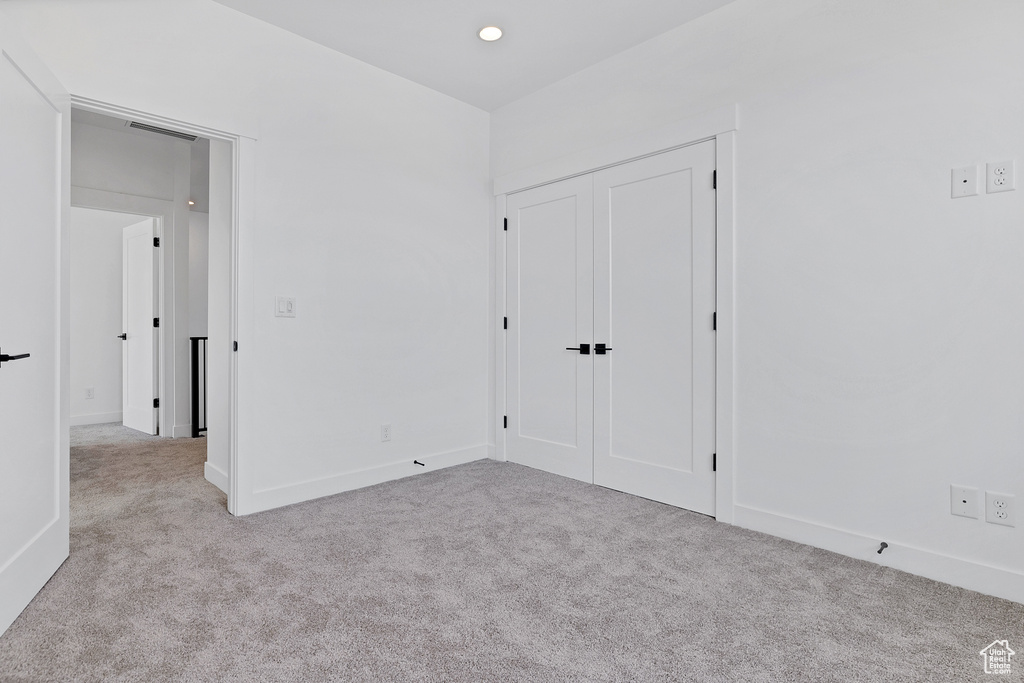 Unfurnished bedroom with carpet flooring and a closet