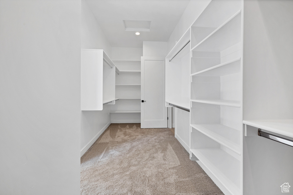 Spacious closet with carpet flooring and attic access