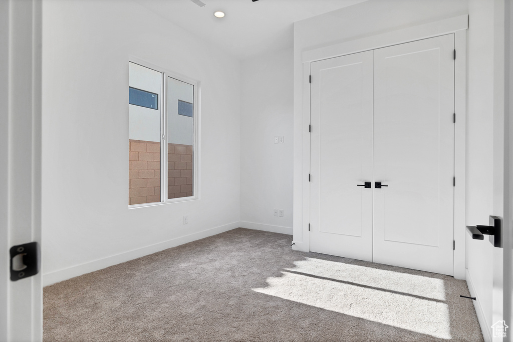 Unfurnished bedroom with carpet floors, a closet, and recessed lighting