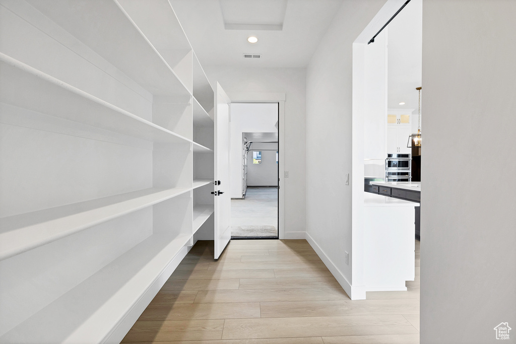Corridor featuring light wood-style flooring and recessed lighting