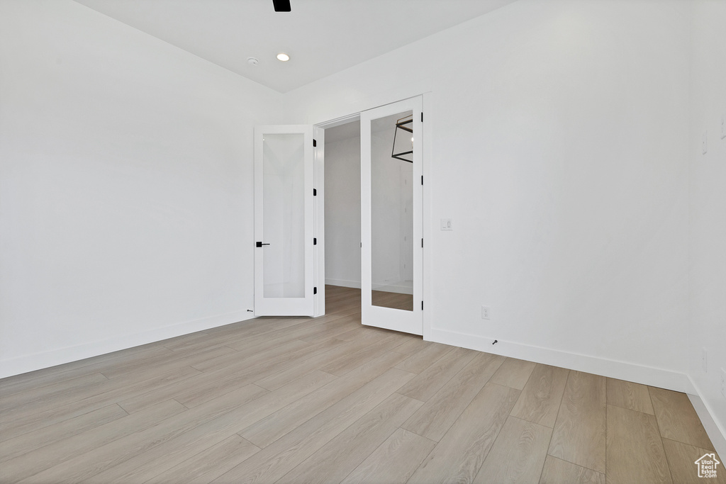 Empty room featuring light wood finished floors, a ceiling fan, and recessed lighting