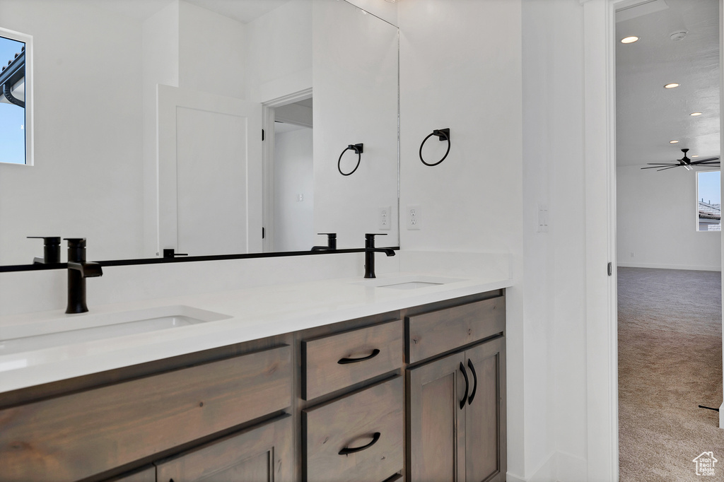 Full bathroom with double vanity, recessed lighting, and ceiling fan