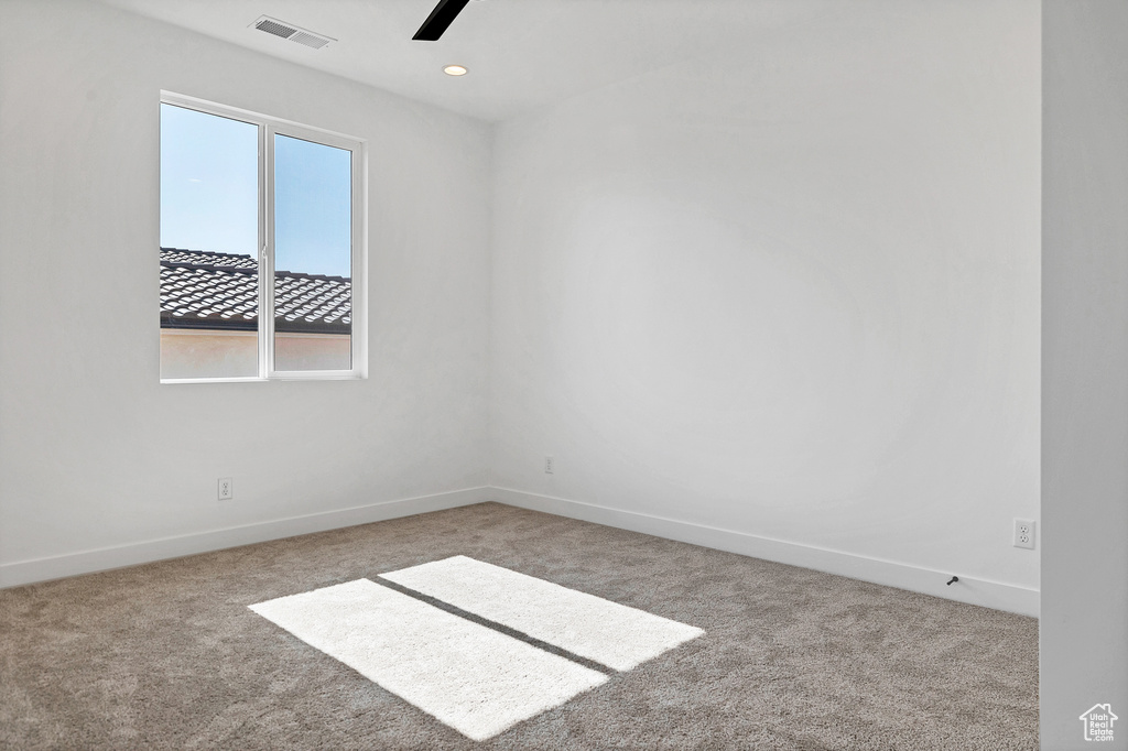 Carpeted spare room featuring a ceiling fan and recessed lighting