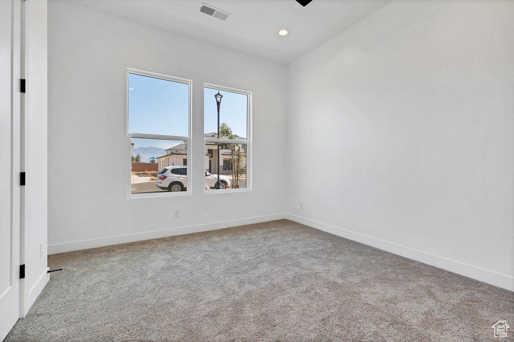 Carpeted spare room with baseboards and recessed lighting
