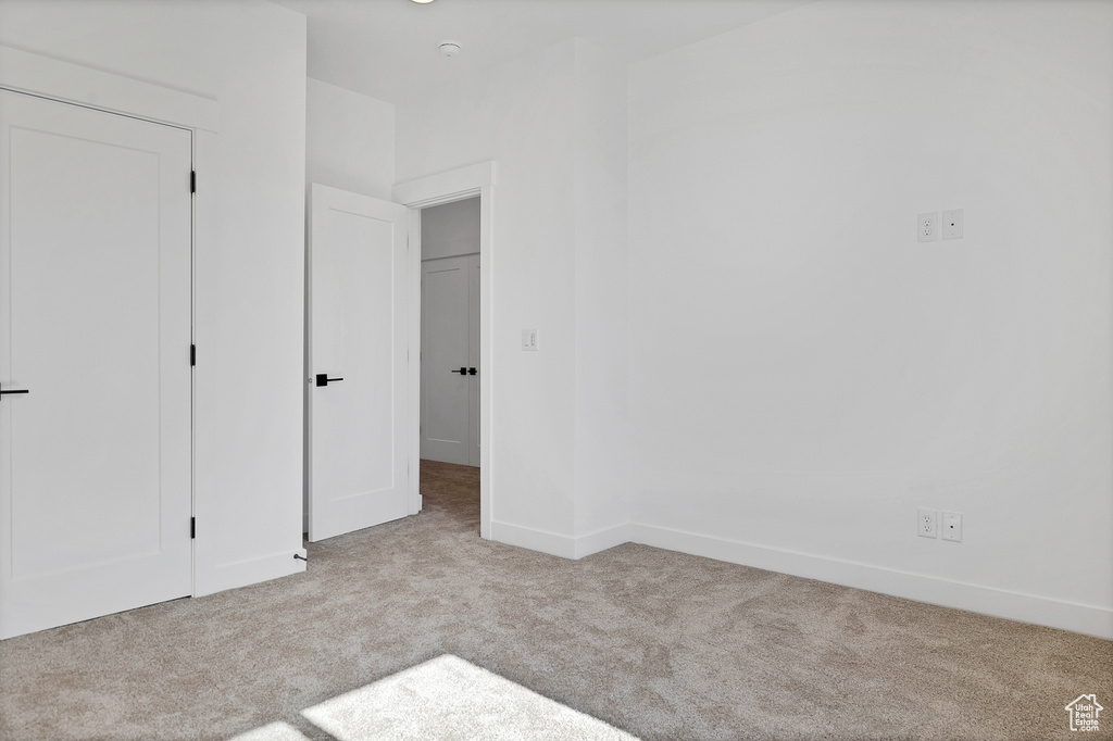 Unfurnished bedroom featuring carpet floors and baseboards