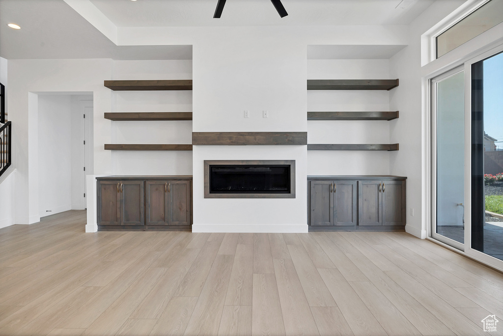 Unfurnished living room with light wood-type flooring, a fireplace, stairway, recessed lighting, and ceiling fan