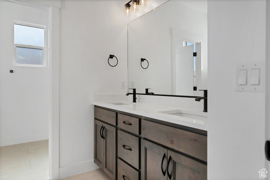 Bathroom with double vanity and tile patterned flooring