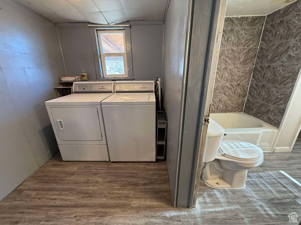 Laundry room with hardwood / wood-style flooring and washer and clothes dryer