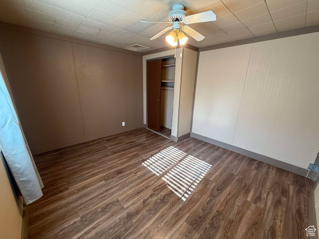 Unfurnished bedroom featuring ceiling fan, dark hardwood / wood-style flooring, and a closet